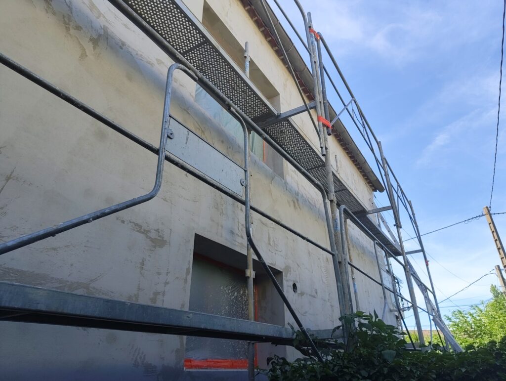 Façade en cours de finition avec application du sous-enduit armé sur isolant lors d'un chantier d'isolation thermique par l'extérieur à Orange