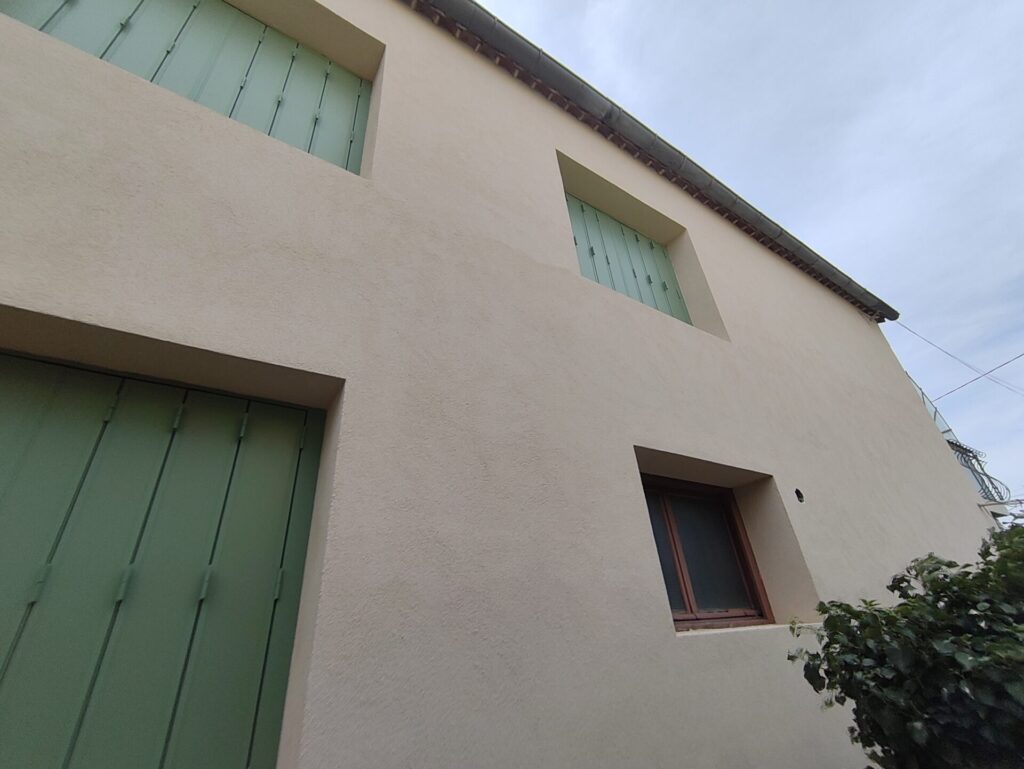 Résultat final d'un chantier ITE à Orange : façade entièrement rénovée avec enduit beige et volets verts, réalisé par A2M Rénovation